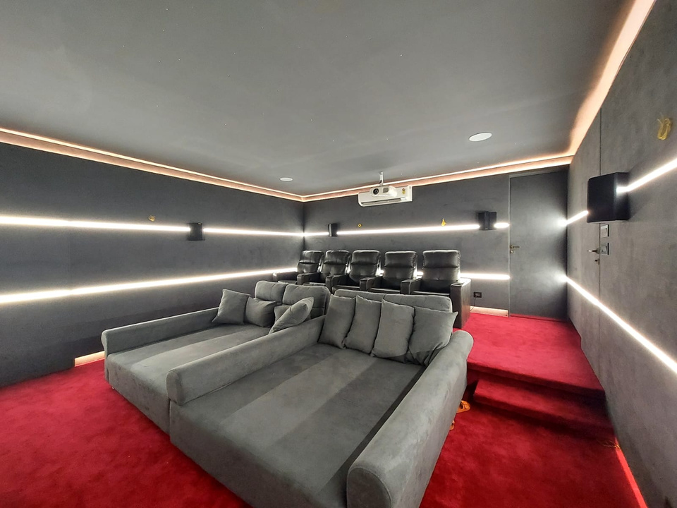 Private home theatre with acoustic velvet walls, recliners and a cinematic screen